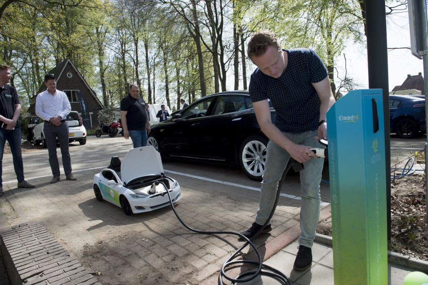 Harm van den Brink, innovator at ElaadNL and Enexis is charging a mini Telsa on the IOTA charging station at the ElaadNL test site in Arnhem, the Netherlands. (PHOTO available in high resolution at ElaadNL)